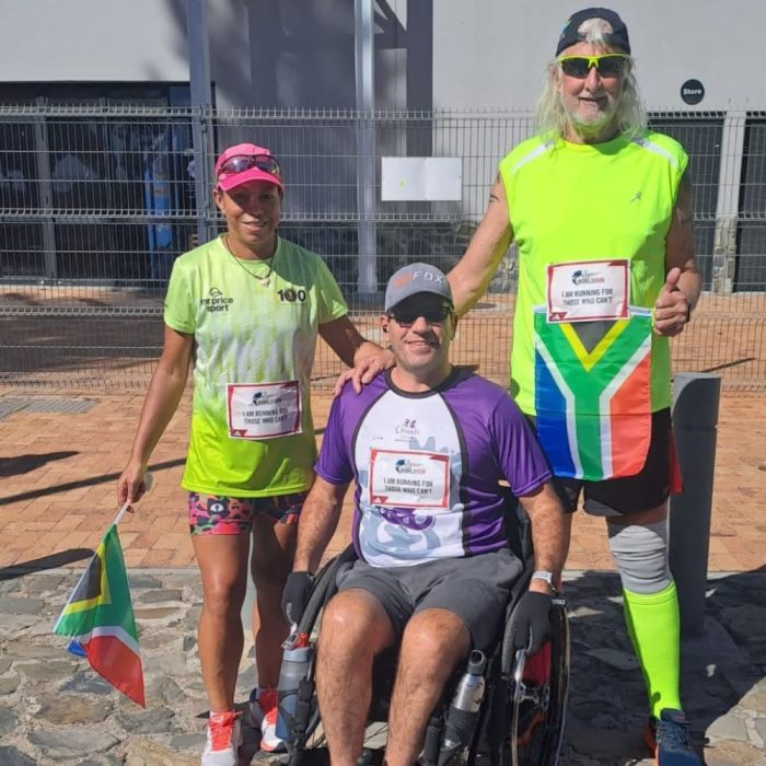 Image of three athletes, one in a wheel chair with South African flags
