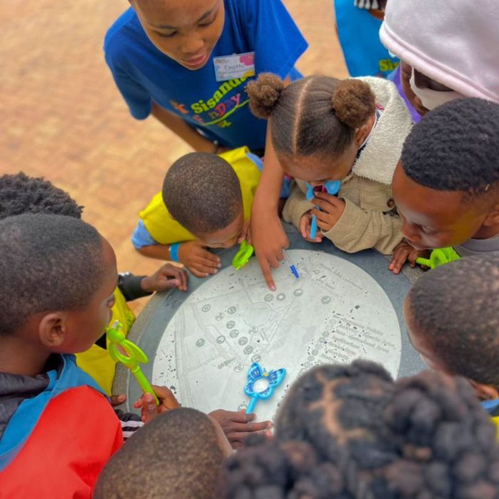 Image of 11 primary school learners working together to solve a clue in a game